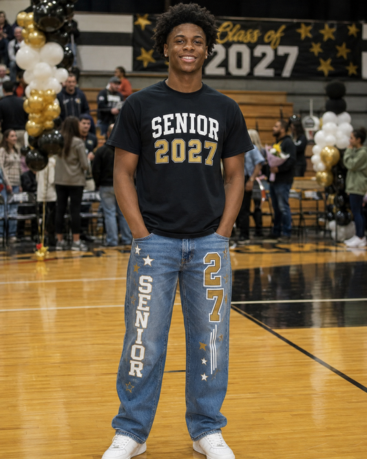 Male senior wearing a custom Senior 2027 shirt and decorated customer-supplied jeans in a school gym